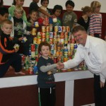 MANAAKITIA TETAHI KI TETAHI: Tokoroa North School student Myles Phayer, 6, demonstrates manaakitanga by presenting ‘Canaakitanga Day’ cans to Salvation Army worker Colin Bridle.