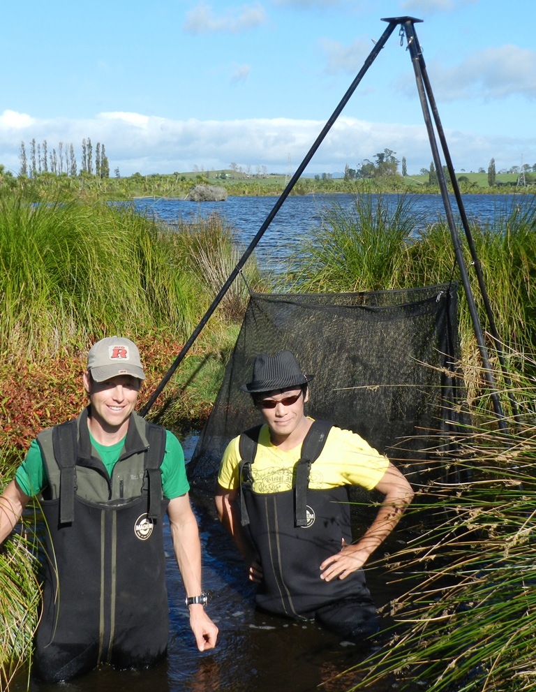 Adam Daniel (left) and Niky Wu set up the new trap in Lake Serpentine.