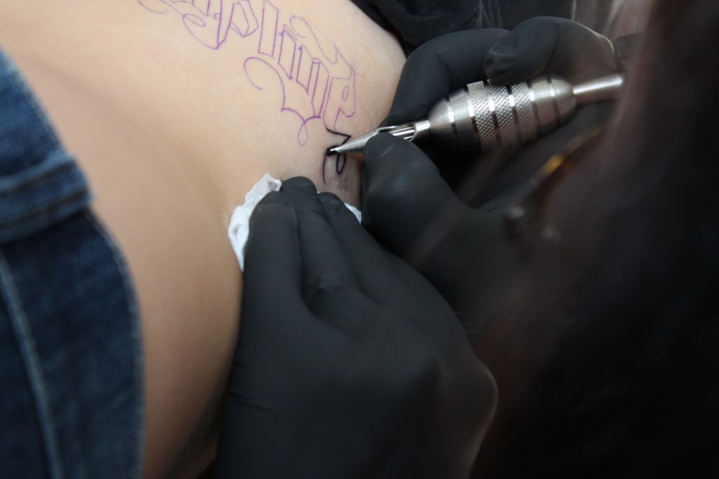 Skinks tattoo artist Aimee works on client. Photo: Karina Yanez