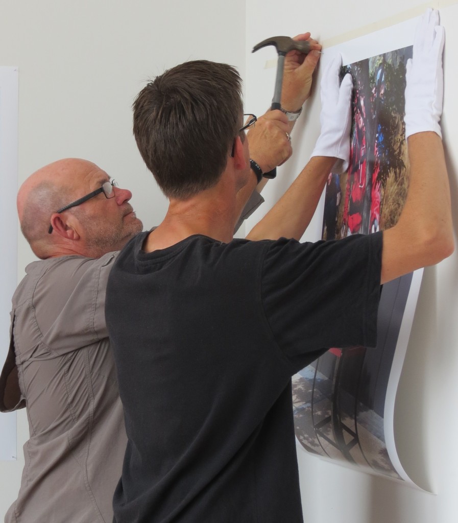 Photographer David Cook and Technician Geoff Ridder hang the final photo