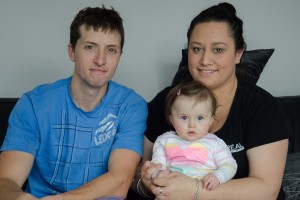 Jonathan Gavin and Shai Ropiha sit with their daughter Ella who is profoundly deaf. Photo: Brad Roberts.