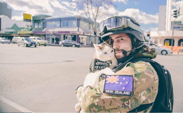 NOT FOR REAL: Cosplay soldier Nathan Vandermaal cuddles a cat in Victoria Street, Hamilton.