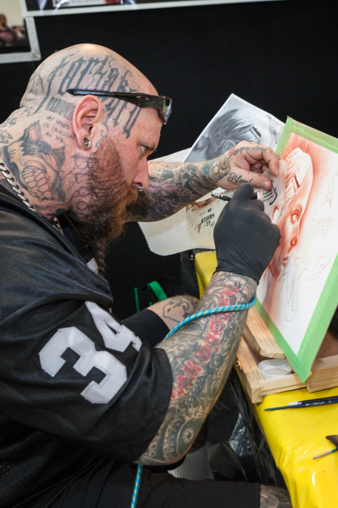 BLOODY TALENTED: Sydney based artist Dr. Rev is painting with blood at International Tattoo Expo. Photo: Christopher Woe 