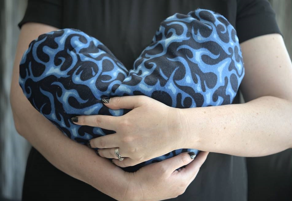 HUGGABLE HEART: Andrea Olliver-Thompson craddles one of her charity's fabric hearts. Photo: Blue Belle Photography
