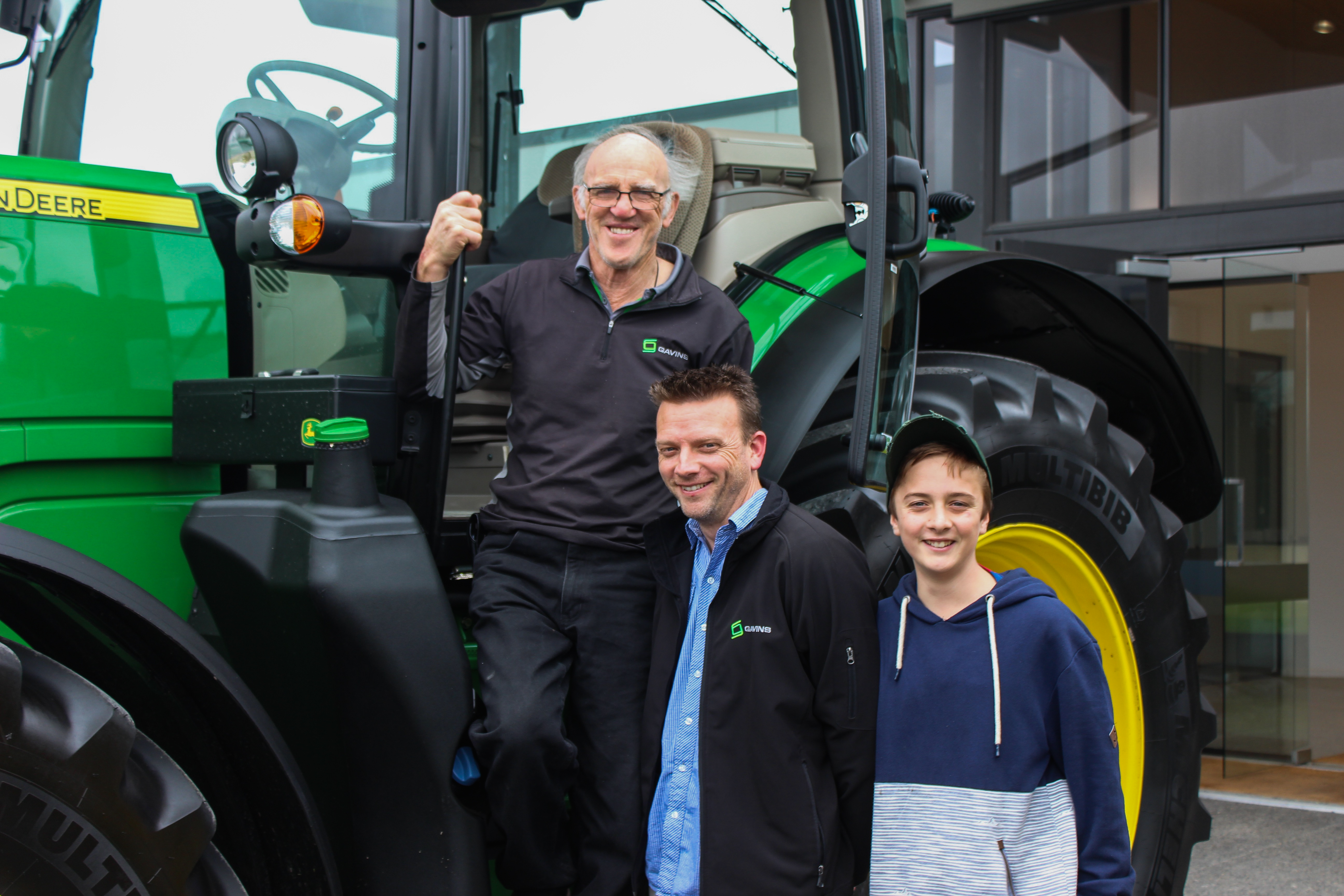 From left to right: Ian Gavin, James Gavin and Caleb Gavin celebrate the purchase of their 100th tractor.